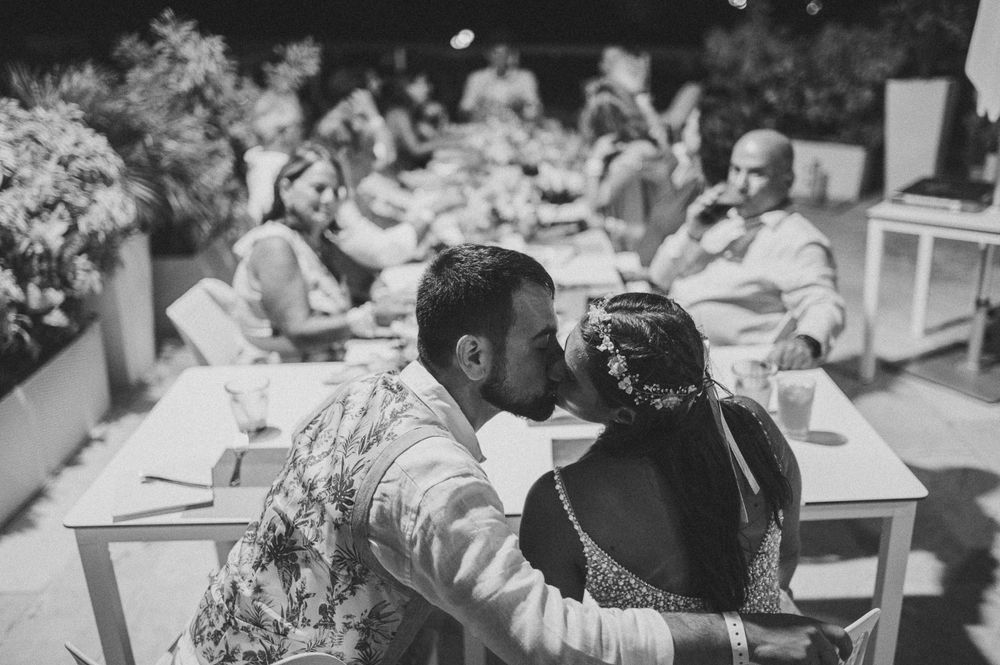 A black and white photo of a couple sharing a tender moment at their outdoor reception.