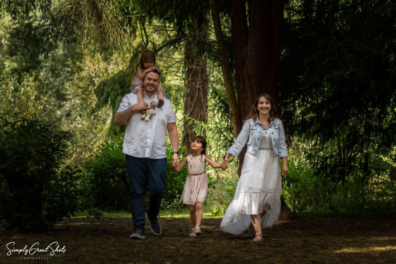 A outdoor family photoshoot - A family of four, strolling through the woods.