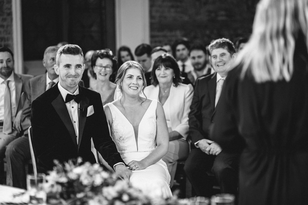 Intimate wedding ceremony in historic brick chapel with gothic windows and natural light.