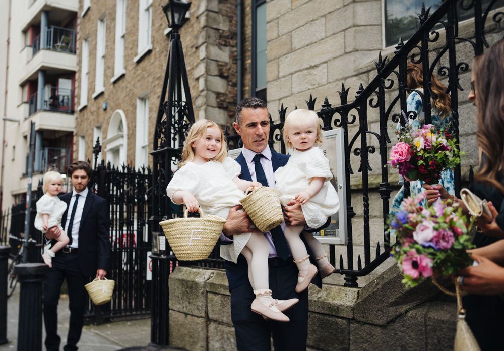 Family moment outside historic building with iron gates and flowers.