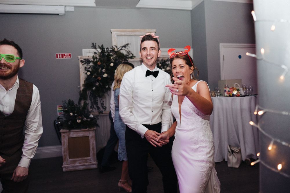 Elegant celebration in a modern venue with formal attire and decorative string lights.