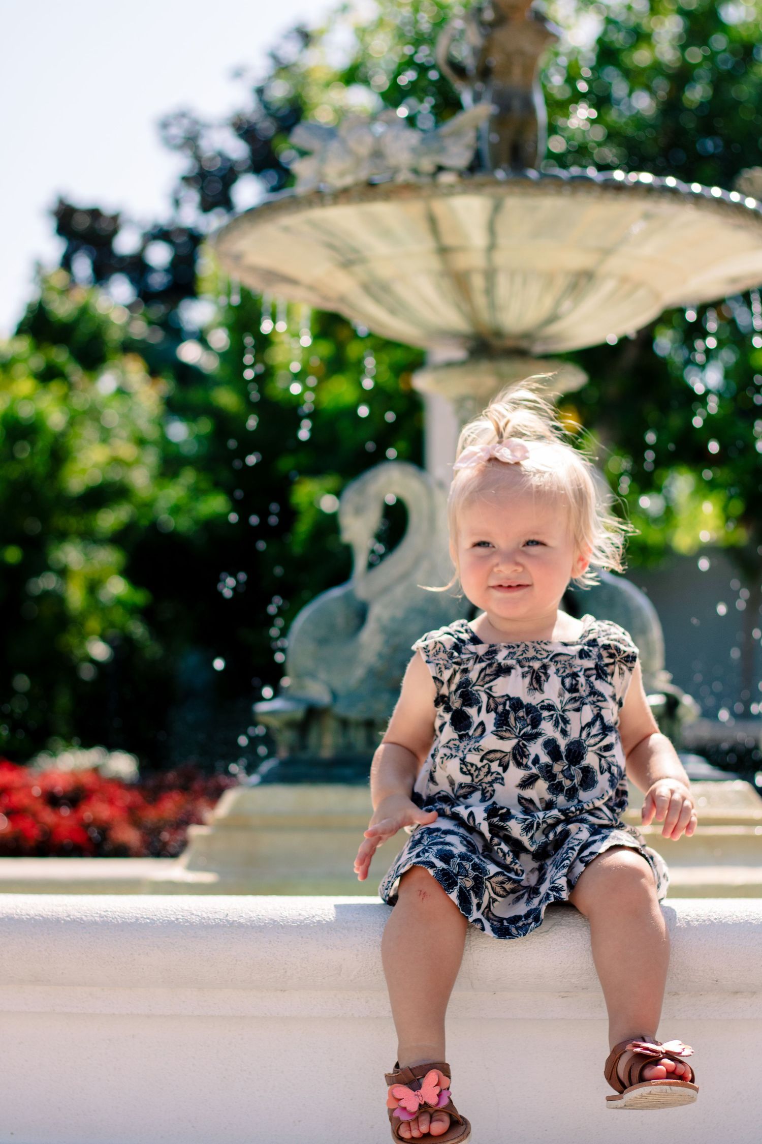 toddler sitting at a water fountain for a photo