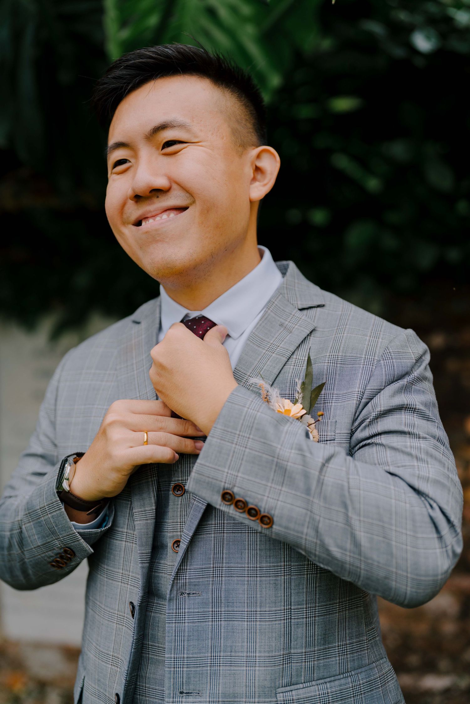 groom adjusting tie on wedding day
