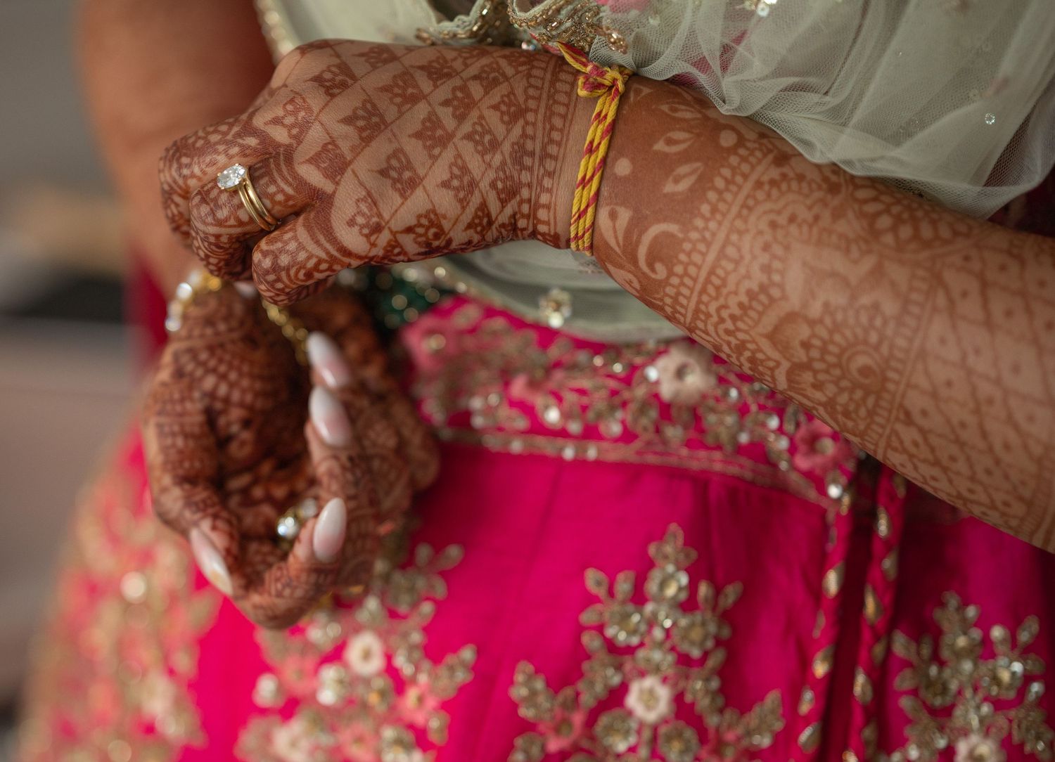 indian bride putting finishing touches to costume