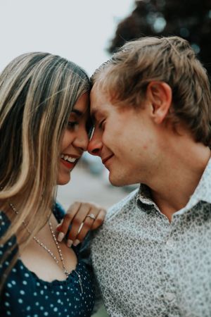 Intimate close up portrait of couple touching foreheads and smiling.