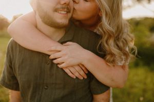 Intimate embrace captured from behind showing genuine affection in warm sunset lighting.