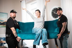 Moving team members interact energetically in modern room with teal couch.