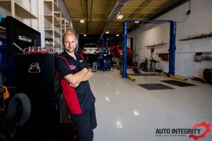 Wide angle view of clean automotive service center with vehicle lifts and work bays.