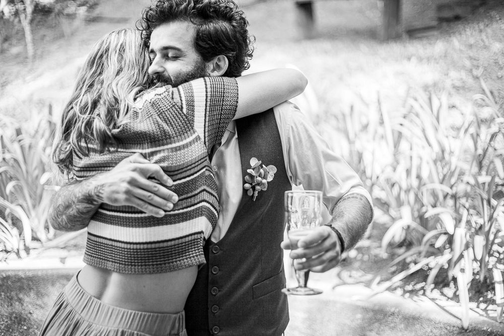A tender black and white moment of two people embracing outdoors.