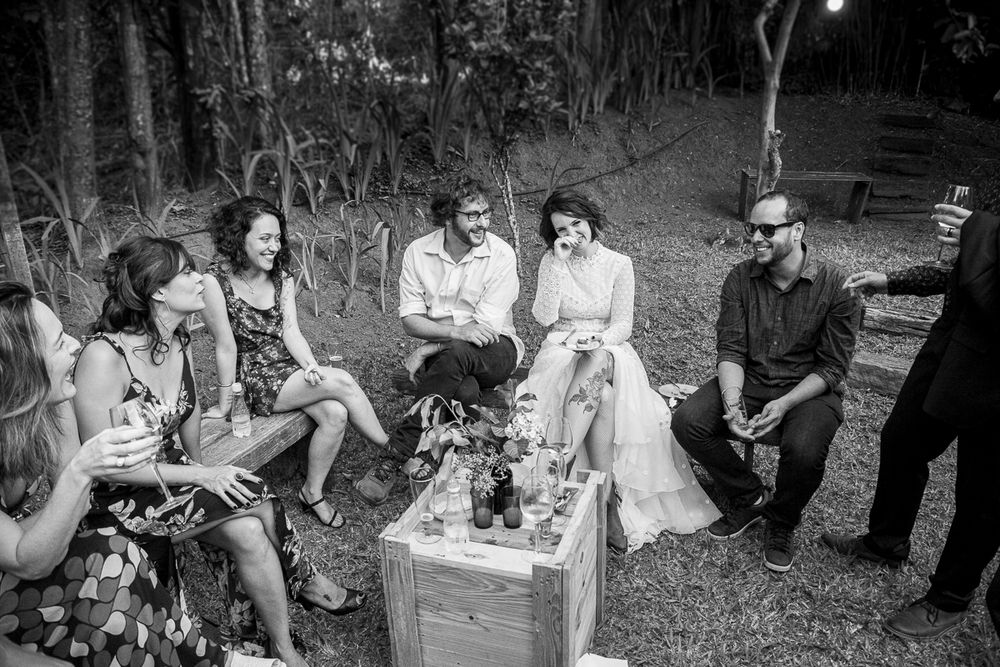 A casual outdoor gathering with people sitting around a wooden crate.