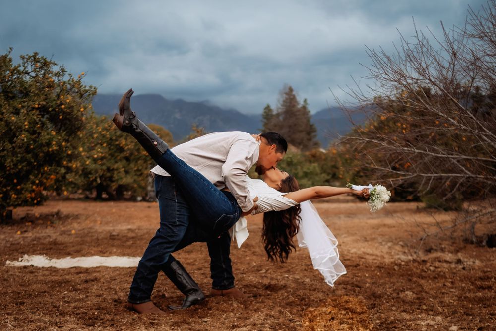 A romantic dance dip captured against a backdrop of mountains and autumn trees in a rustic outdoor setting in Rancho Cucamonga