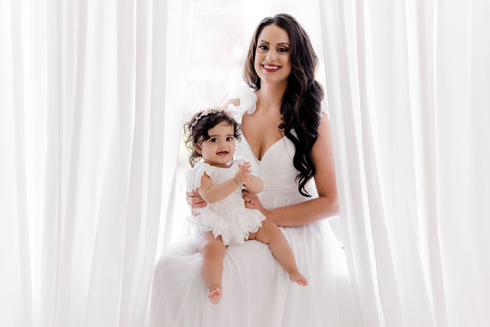 Elegant white studio portrait with flowing dress and romantic lighting.