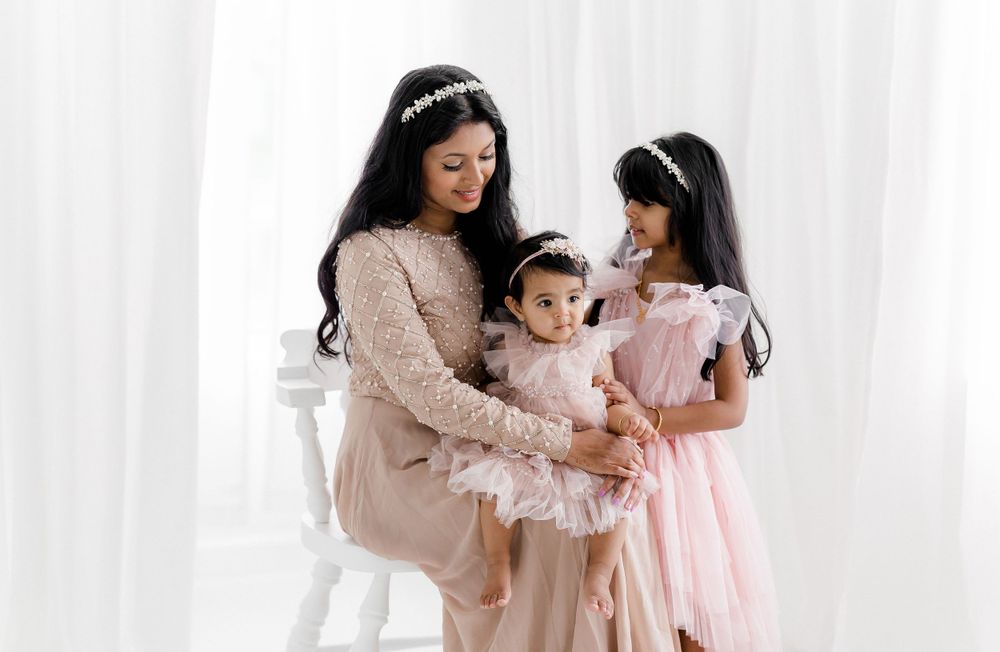 Soft pink studio portrait with delicate lace details and romantic styling.