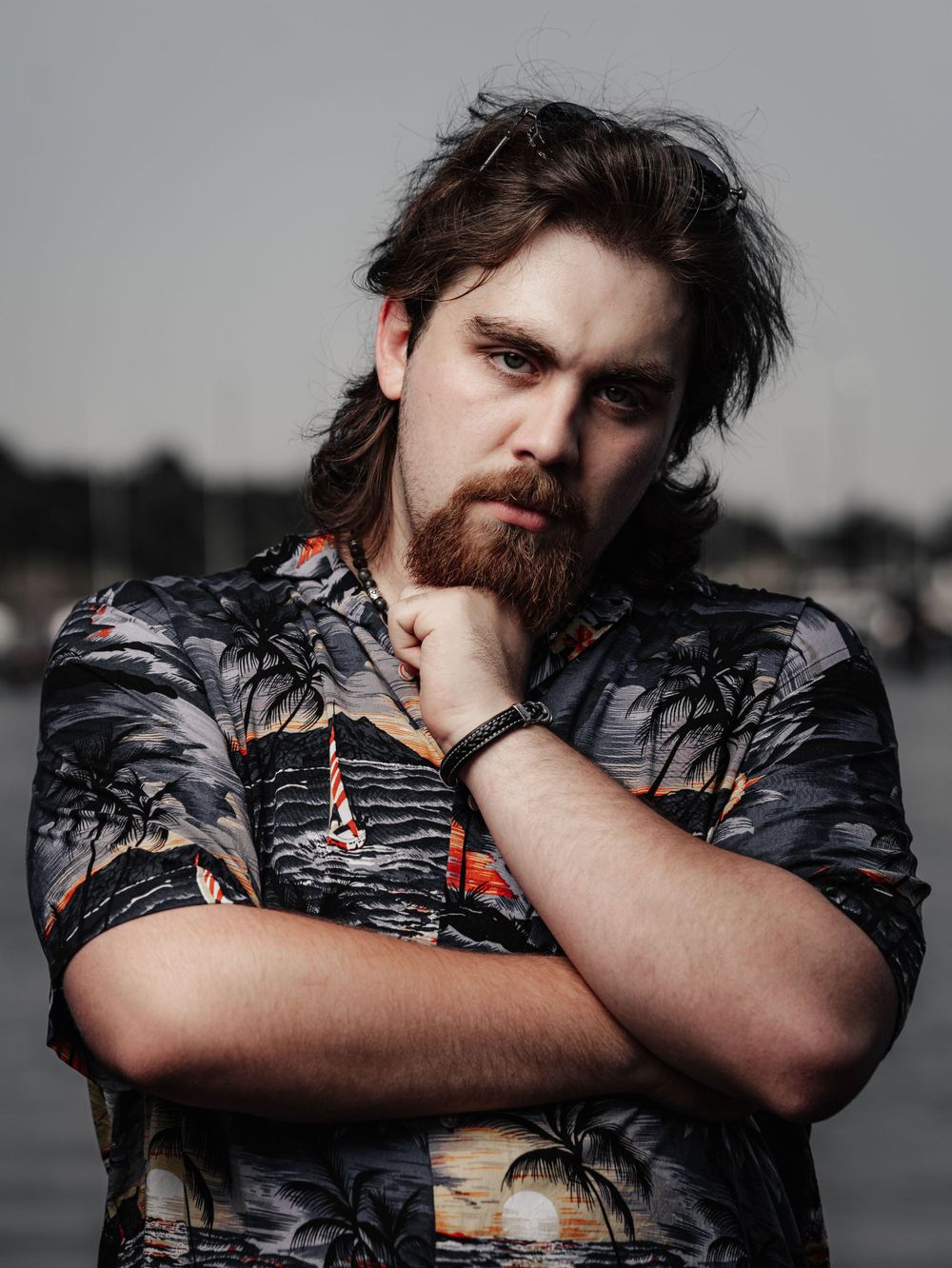 Moody portrait in Hawaiian print shirt against gray background.