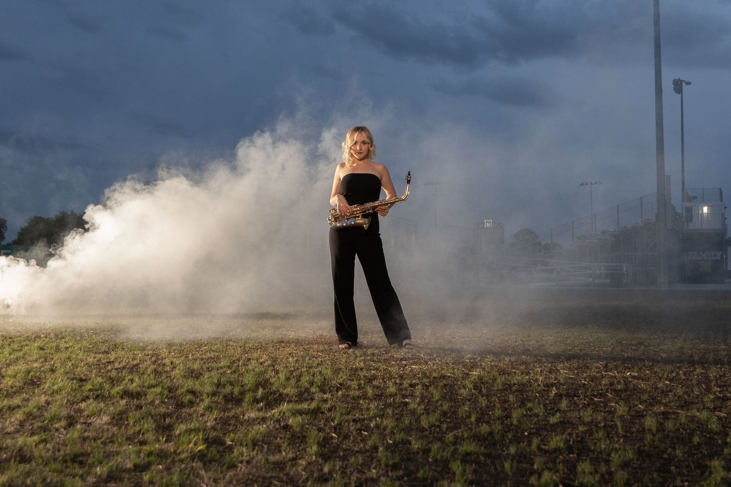 Mattoon, Illinois high school senior strikes a pose with her saxophone while smoke billows in the background.