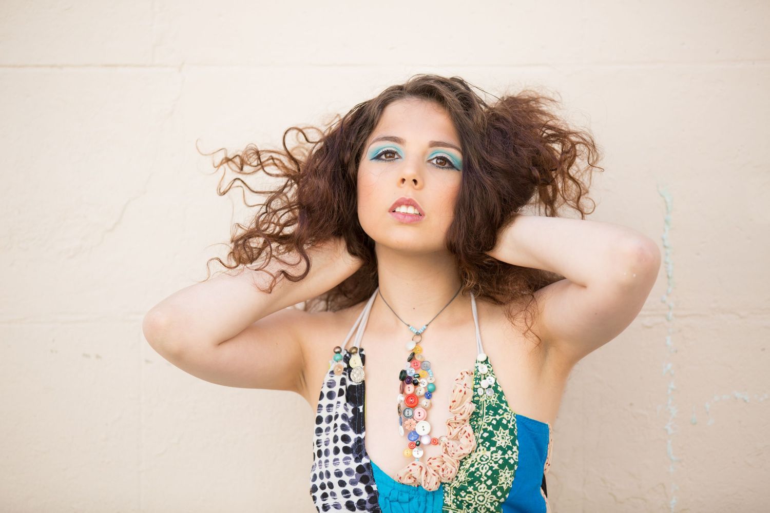 Fashion portrait with dramatic hair movement and colorful statement necklace.