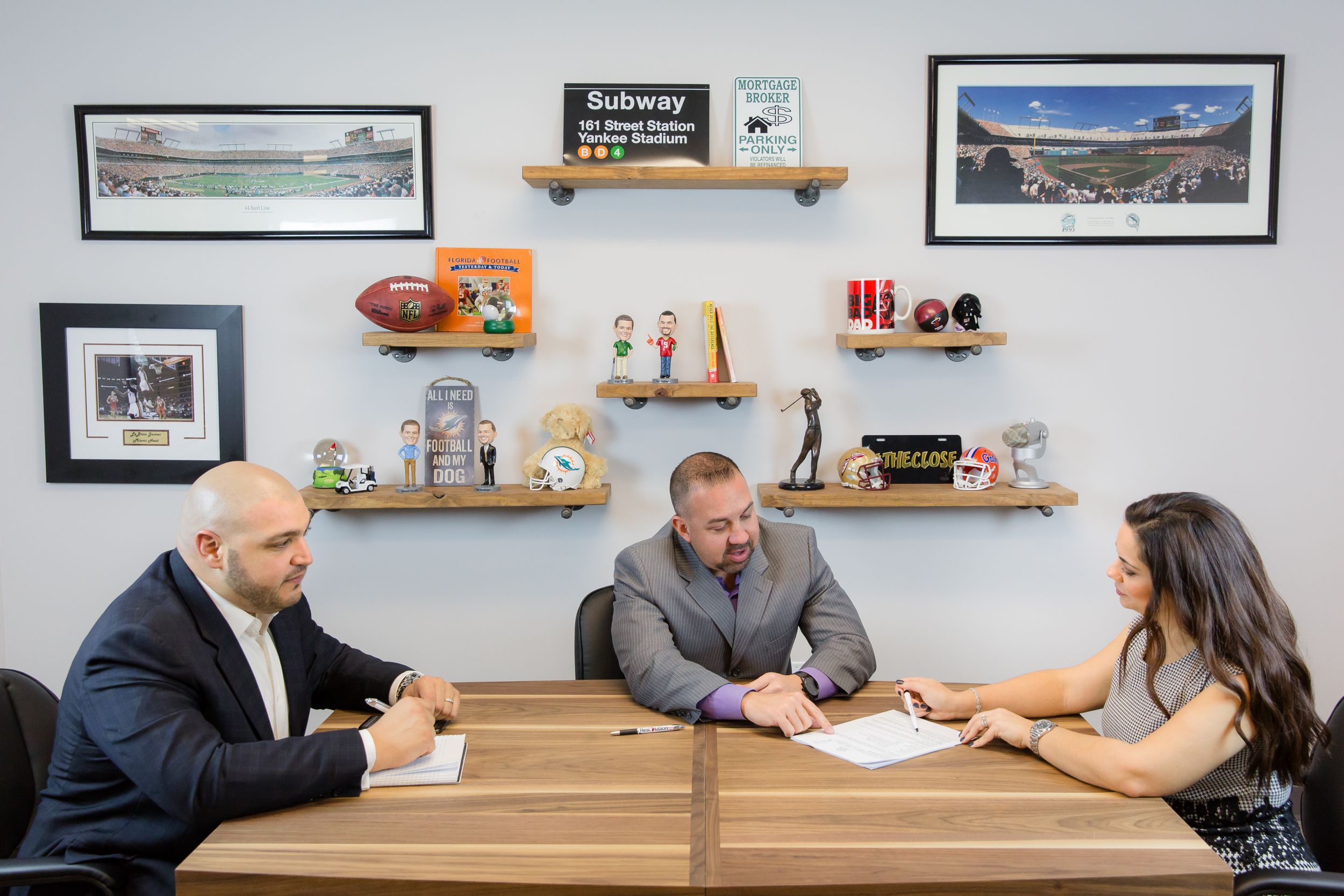 Conference room setting with team members seated at wooden table discussing business.