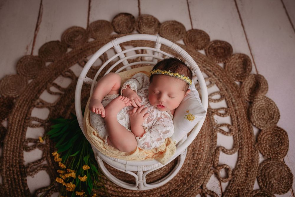 newborn baby girl sleeping in little chair