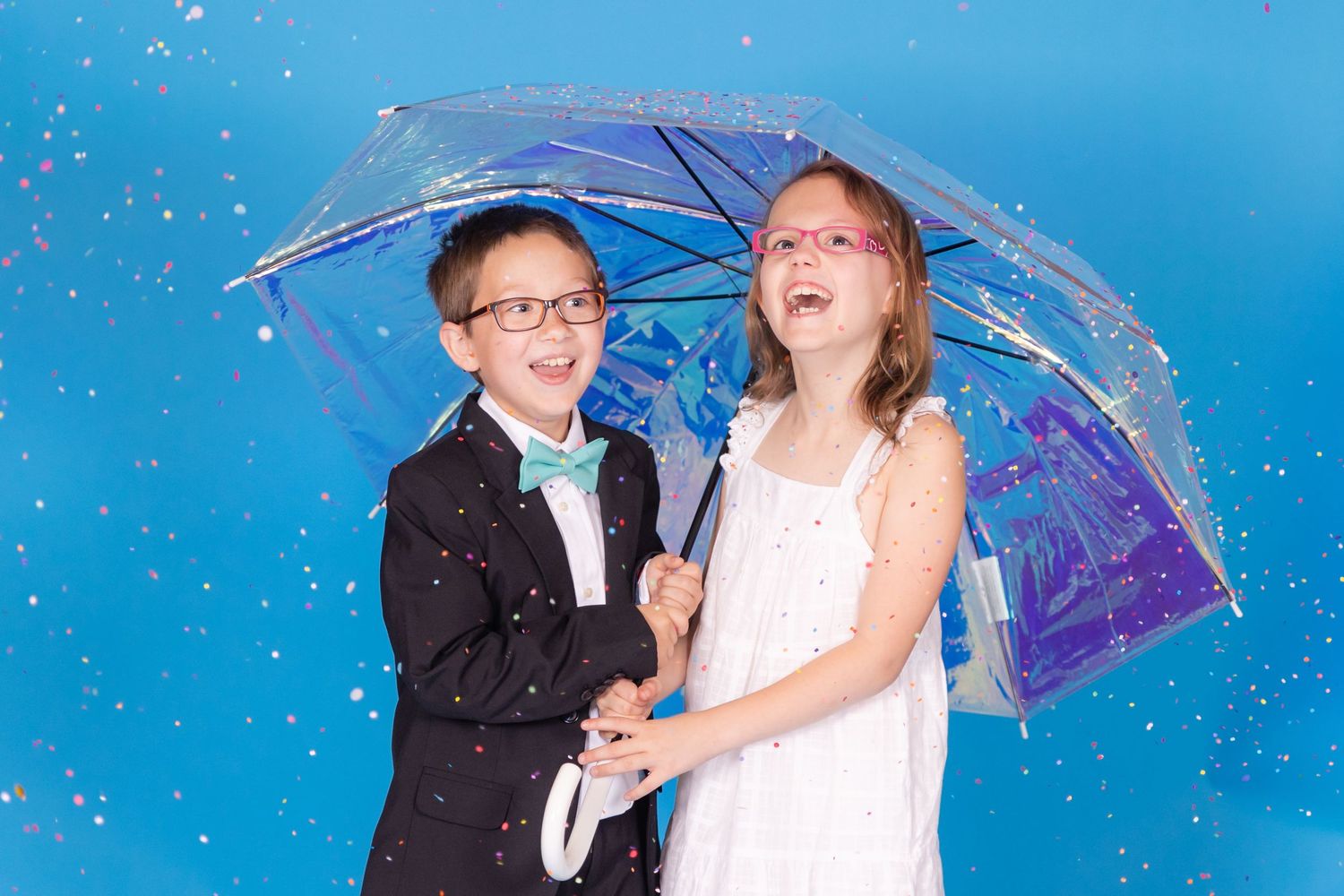 child holding irridescent umbrella on savage blue jay backdrop with confetti in studio in clayton new jersey Gloucester