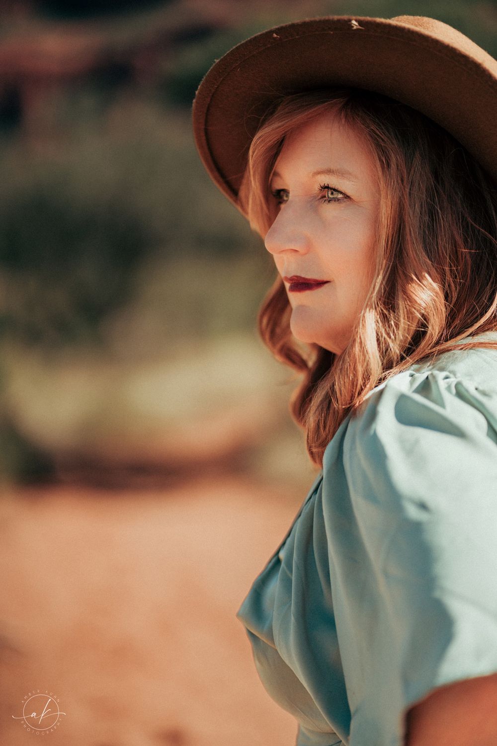 Western inspired portrait with brown hat and mint blouse against Sedona desert backdrop.