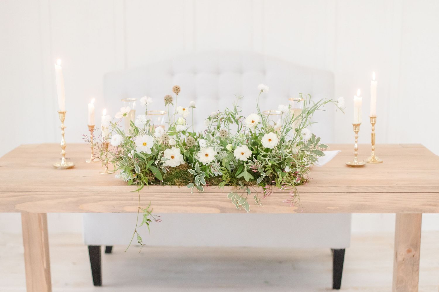 Rustic wooden table decorated with greenery and candles for an elegant wedding reception.
