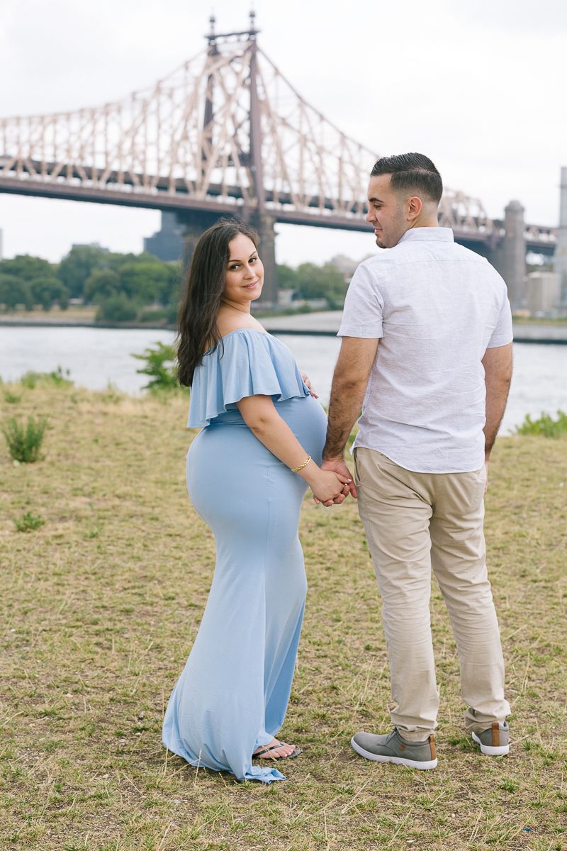 a couple hold hands during their maternity photoshoot in NYC by maternity photographer Paula Ortiz