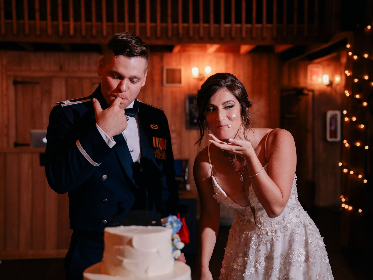 Couple sharing a thoughtful moment while looking at their wedding cake.