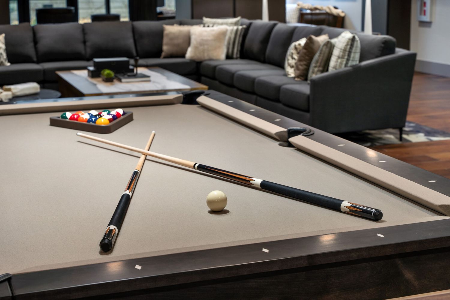 Pool cues and billiard balls rest on a gray felt table in a modern apartment community room in downtown Columbus, Ohio.