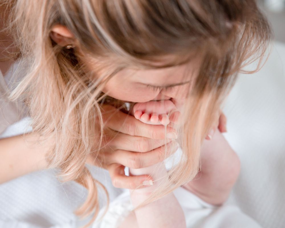 mother kissing baby feet