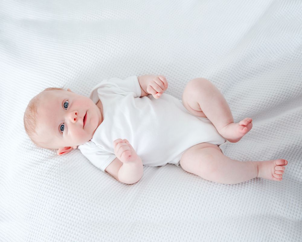 baby girl lying on bed