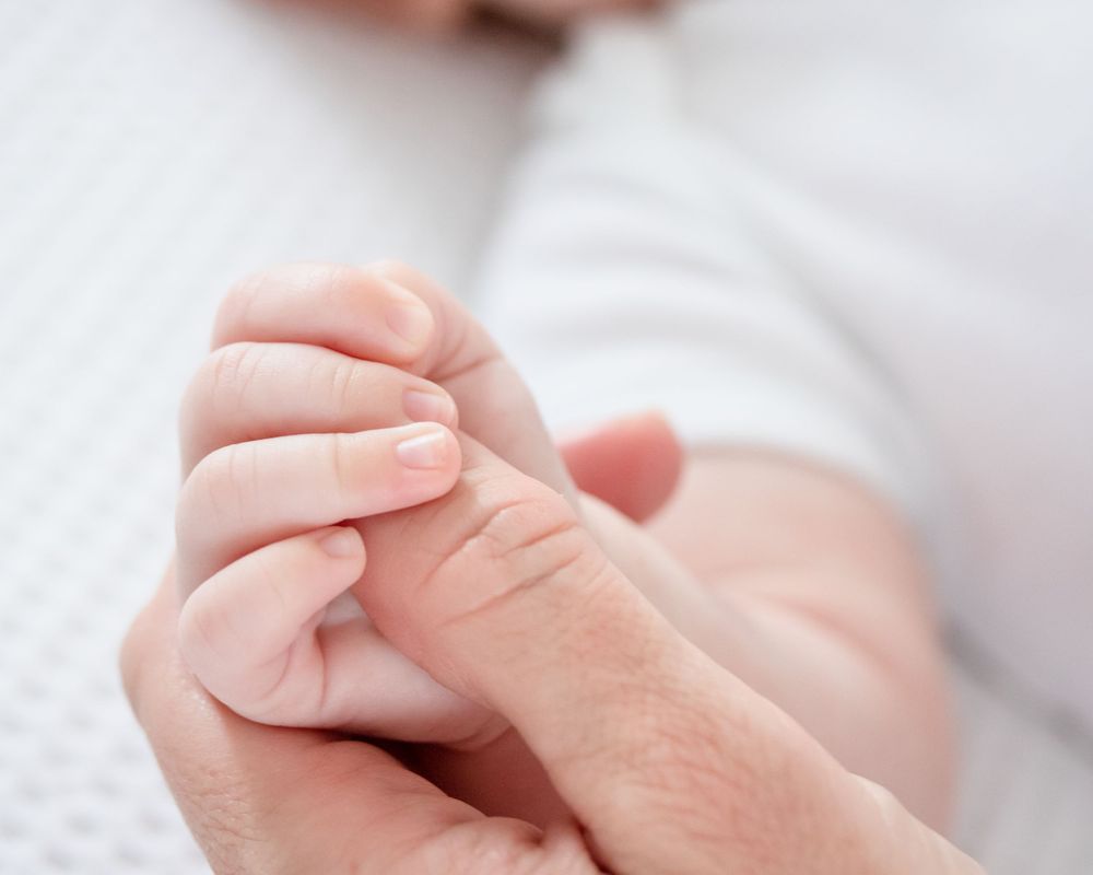 close up of baby hands in mothers