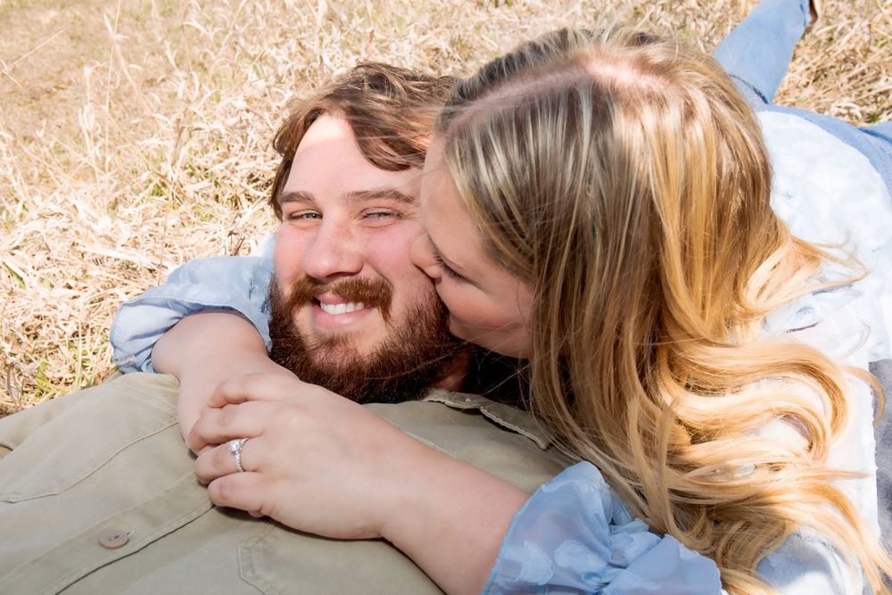 Sweet outdoor photo of couple sharing affectionate moment on grass.
