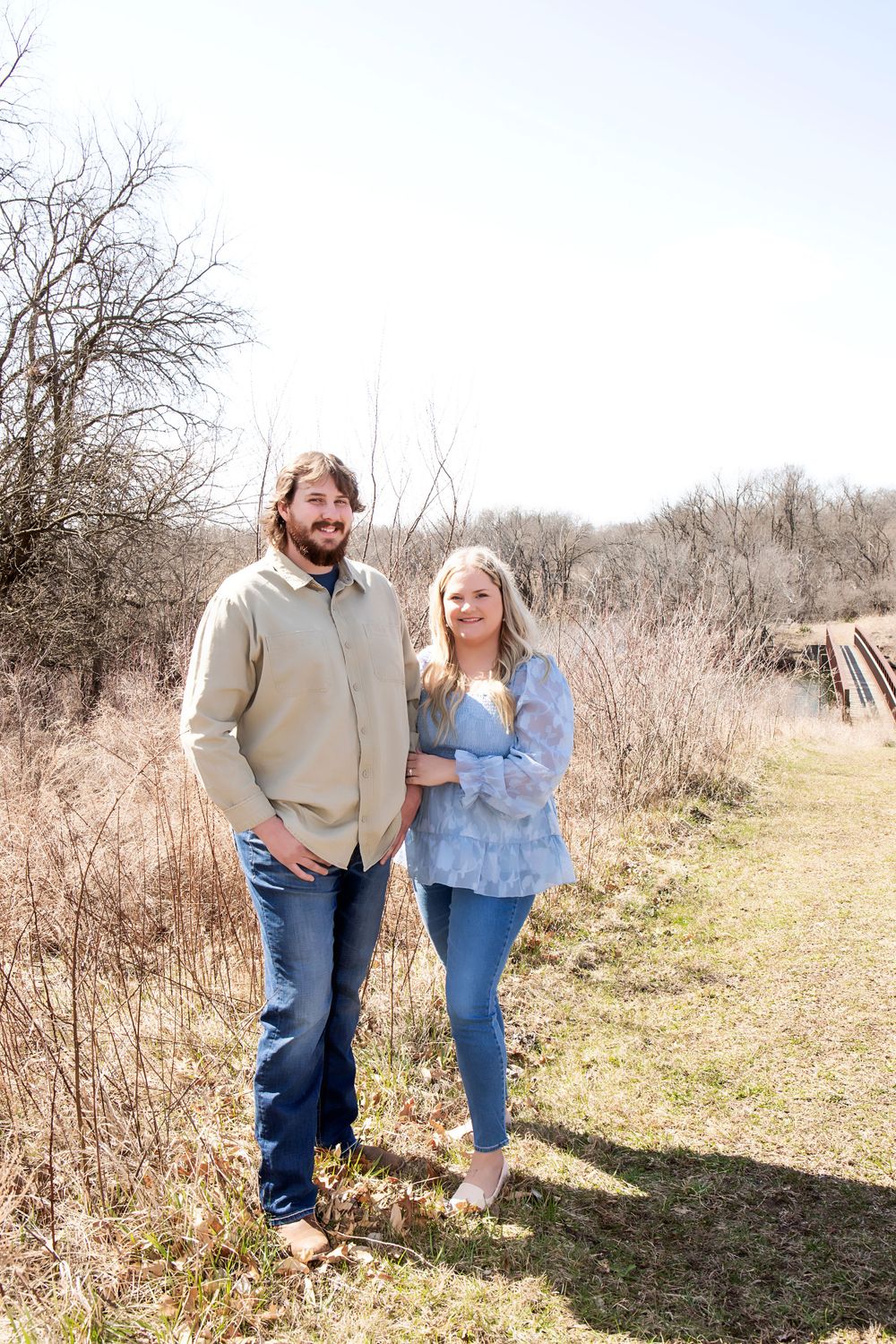Couple standing together on a nature path during an early spring day.