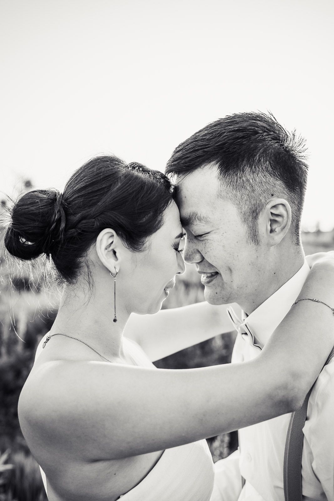 Black and white photo of husband and wife with foreheads together.
