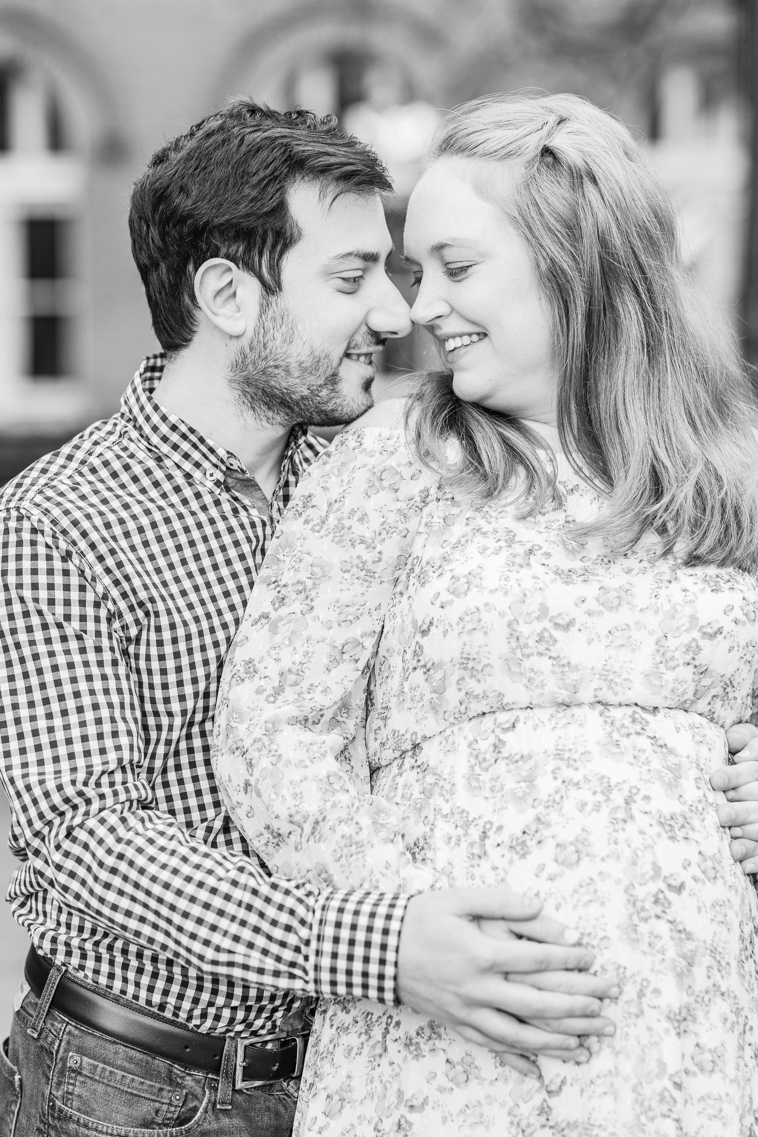 A couple shares an intimate moment in black and white photography.