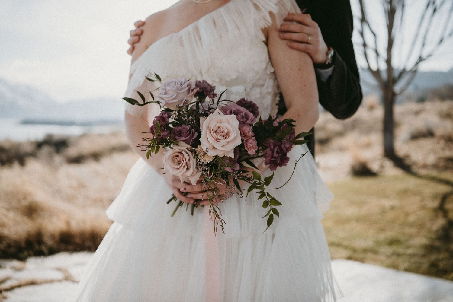 Kelowna wedding photo of bride and groom standing at the alter. Photo is focused on bridal bouquet