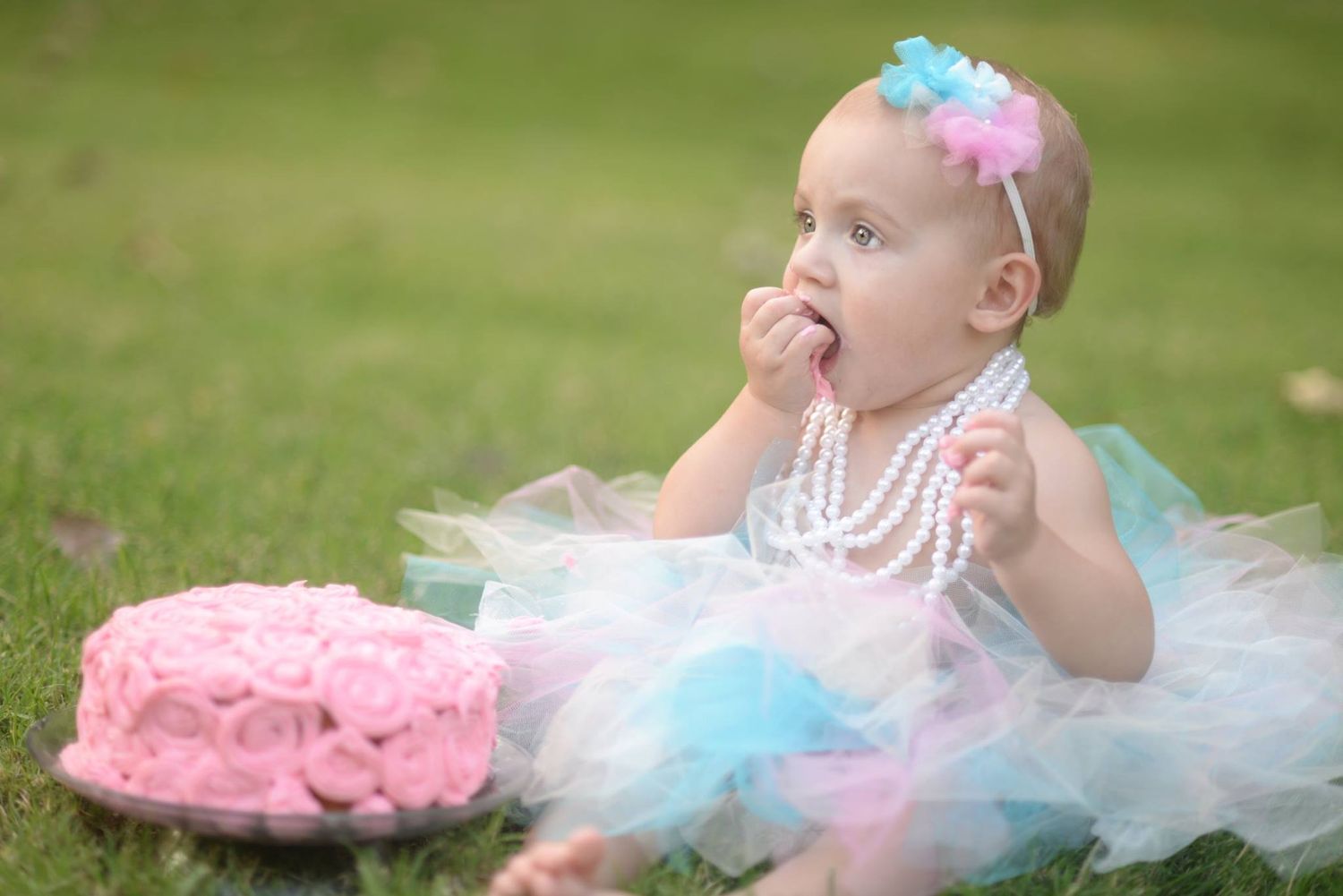 baby in tutu eating cake with hands
