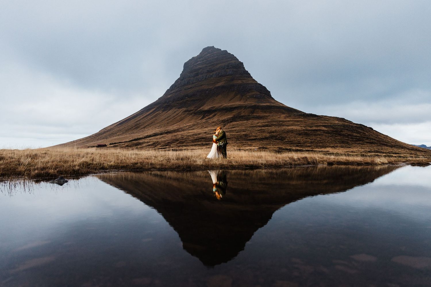 Stunning mountain reflection in still water creates perfect mirror image in moody landscape.