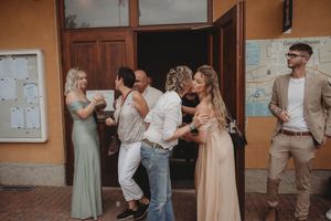 Wedding guests celebrating and dancing outside a building.