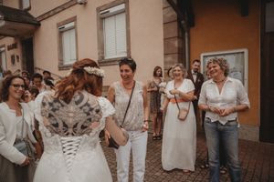 Wedding guests mingle outside a building during the celebration.