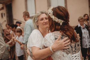 An emotional moment captured during wedding celebrations with guests gathered outside.