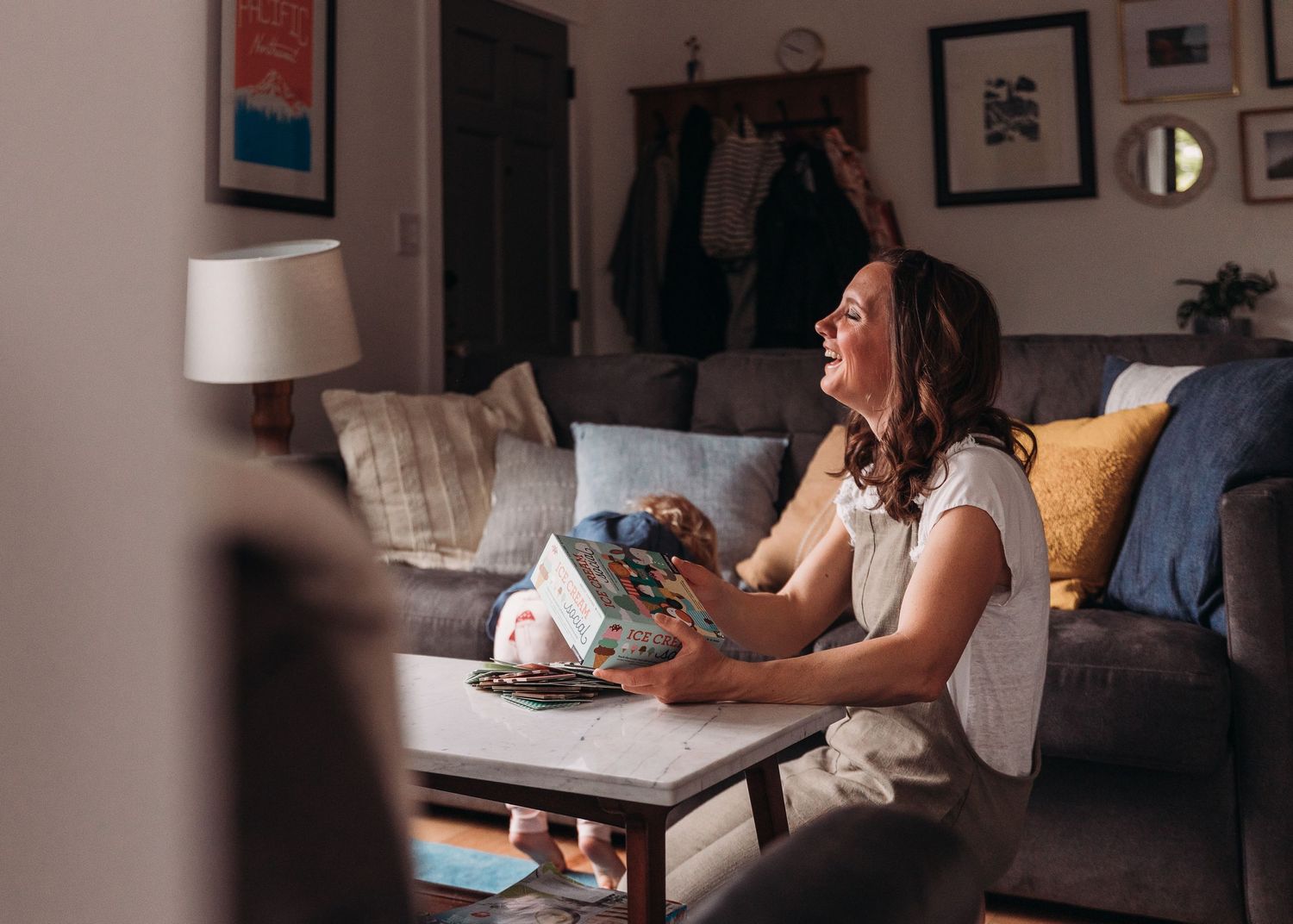 Person enjoying a relaxing evening on the couch with a warm drink in a cozy living room setting.