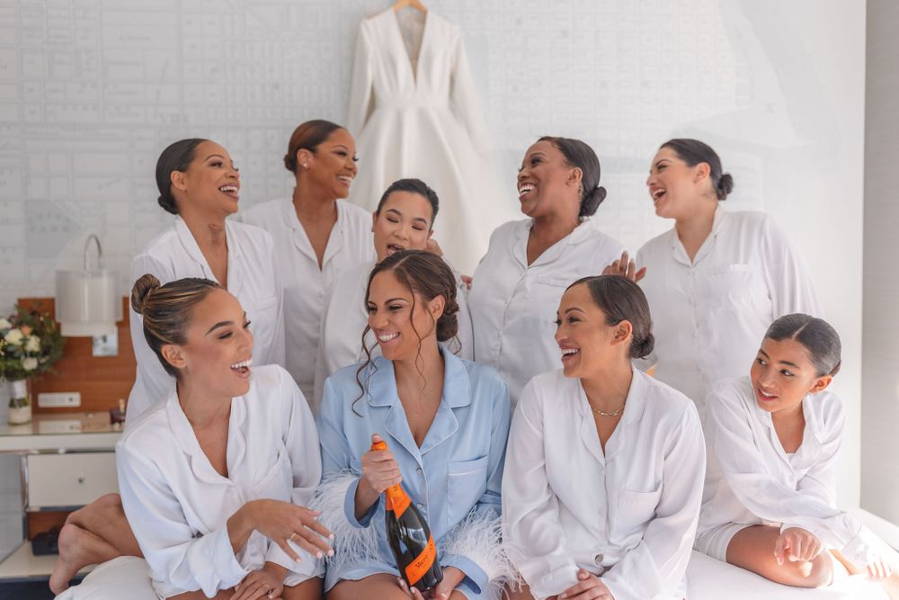 A group celebrates with champagne while wearing matching white robes.