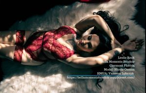 Artistic boudoir photography in red lingerie with dramatic lighting and water effects.