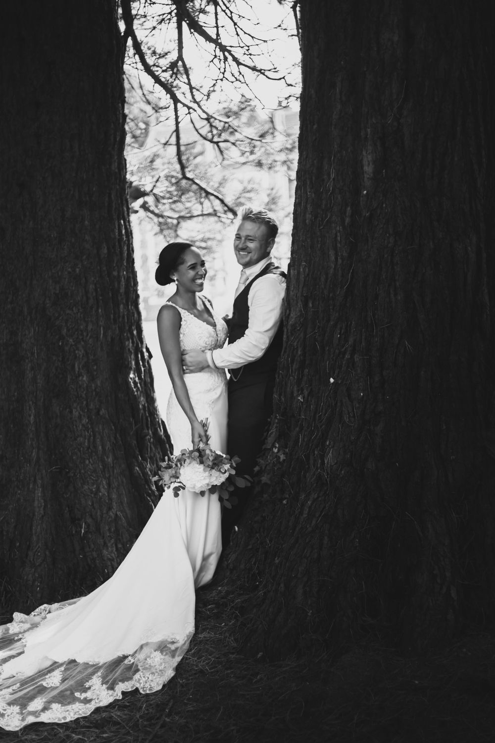 bride and groom leaning on tree