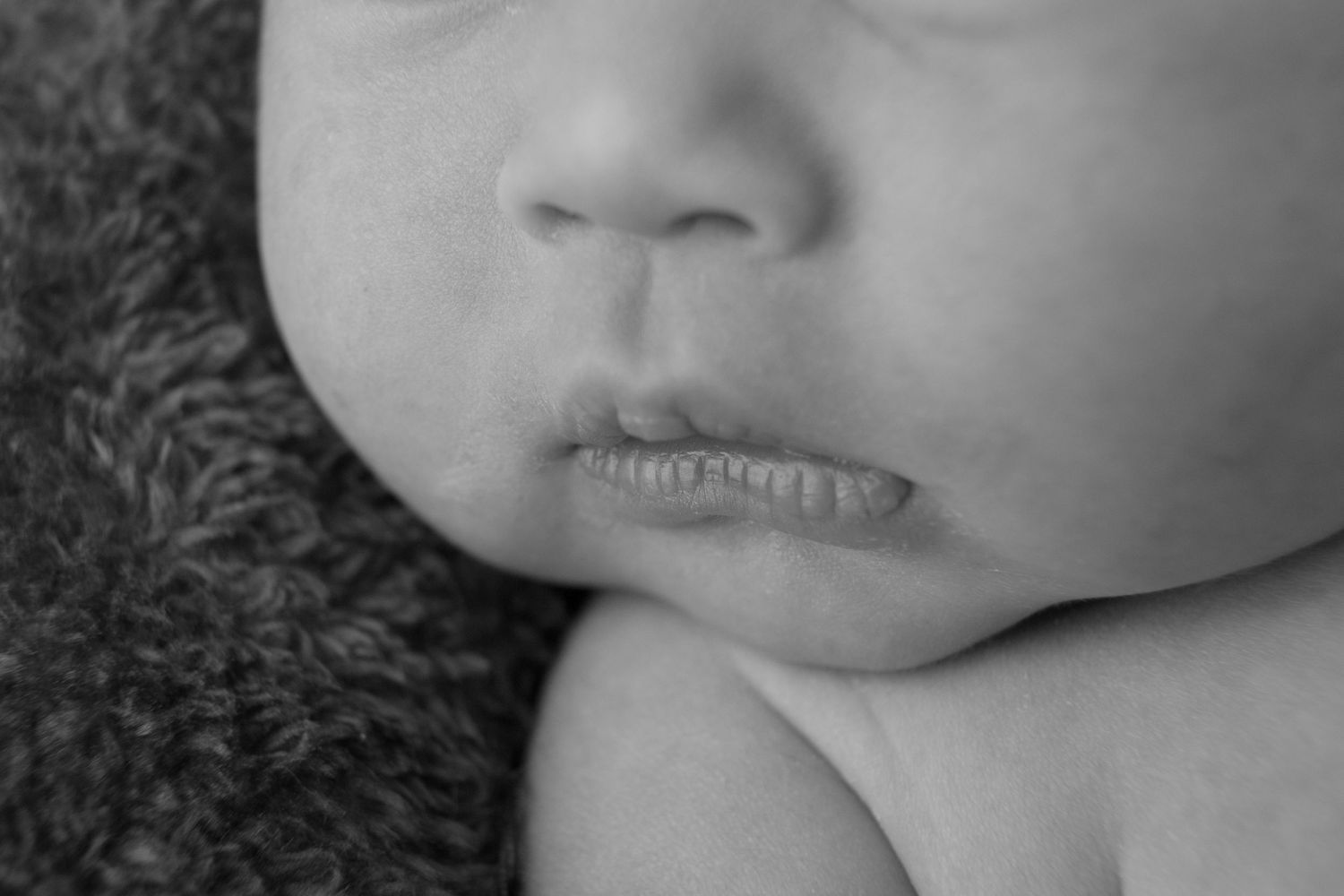 Close-up black and white macro shot capturing infant's delicate features.