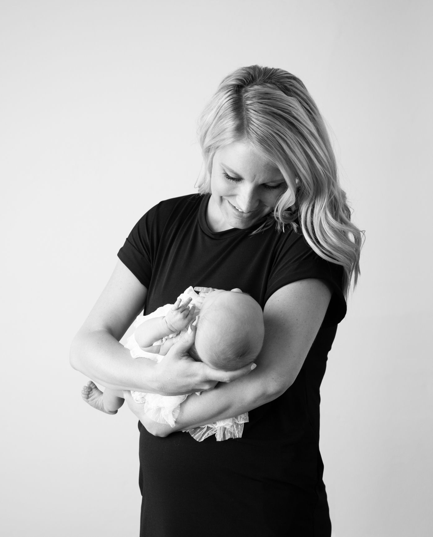 Black and white portrait of tender moment between parent and newborn.