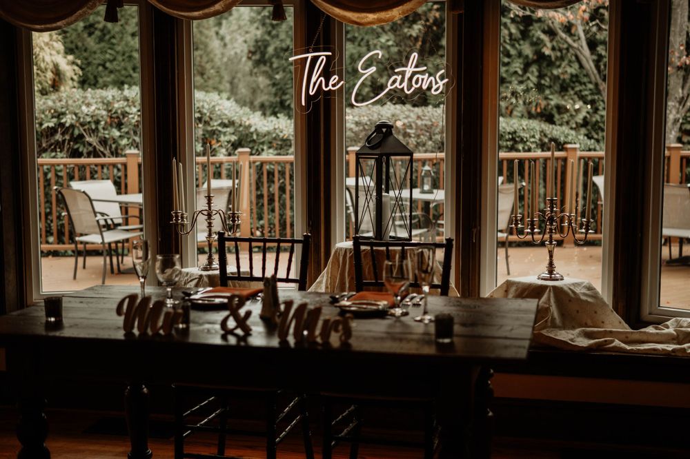 Rustic outdoor wedding venue with wooden beams and elegant table settings in a natural setting.
