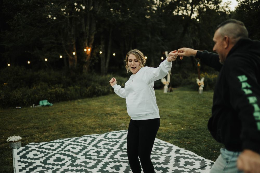 Outdoor evening party with string lights and black and white patterned blanket.