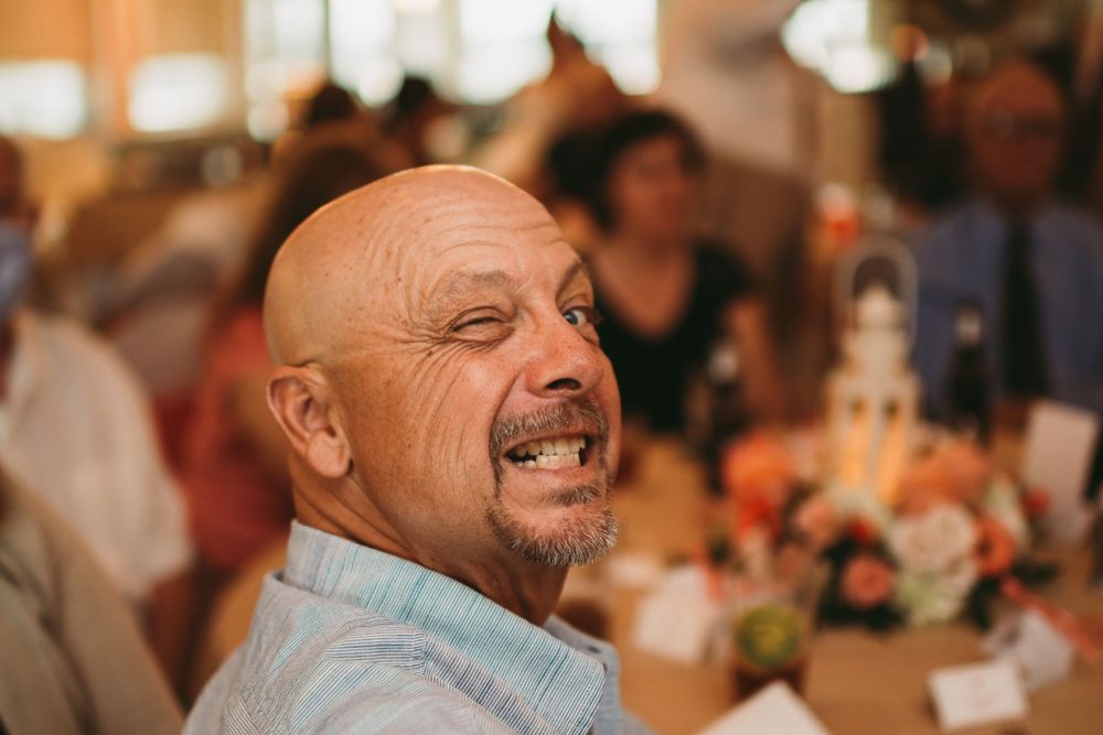 Indoor event scene with warm lighting and blurred background showing guests at a celebration.